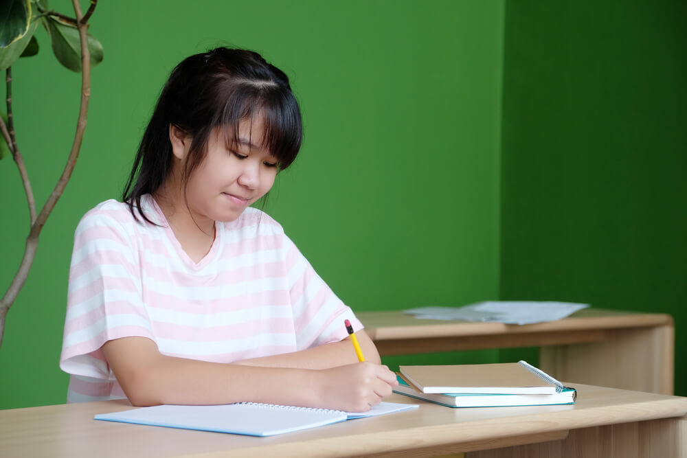 An english language learner writes in her journal.