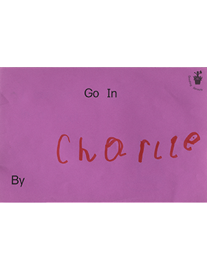 A little purple card that has a handwritten name of Charlie on it in red marker.