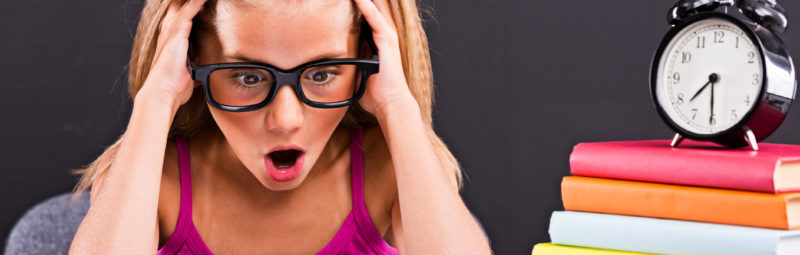 stressed out female student sitting next to a alarm clock