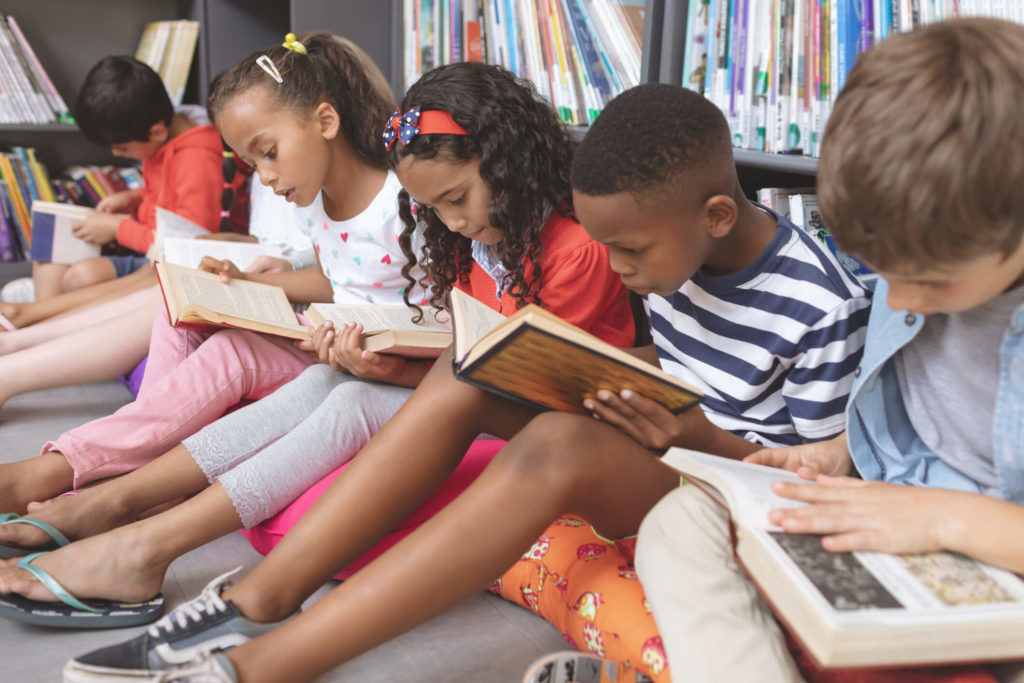 A group of students reading non-fiction books together in the library