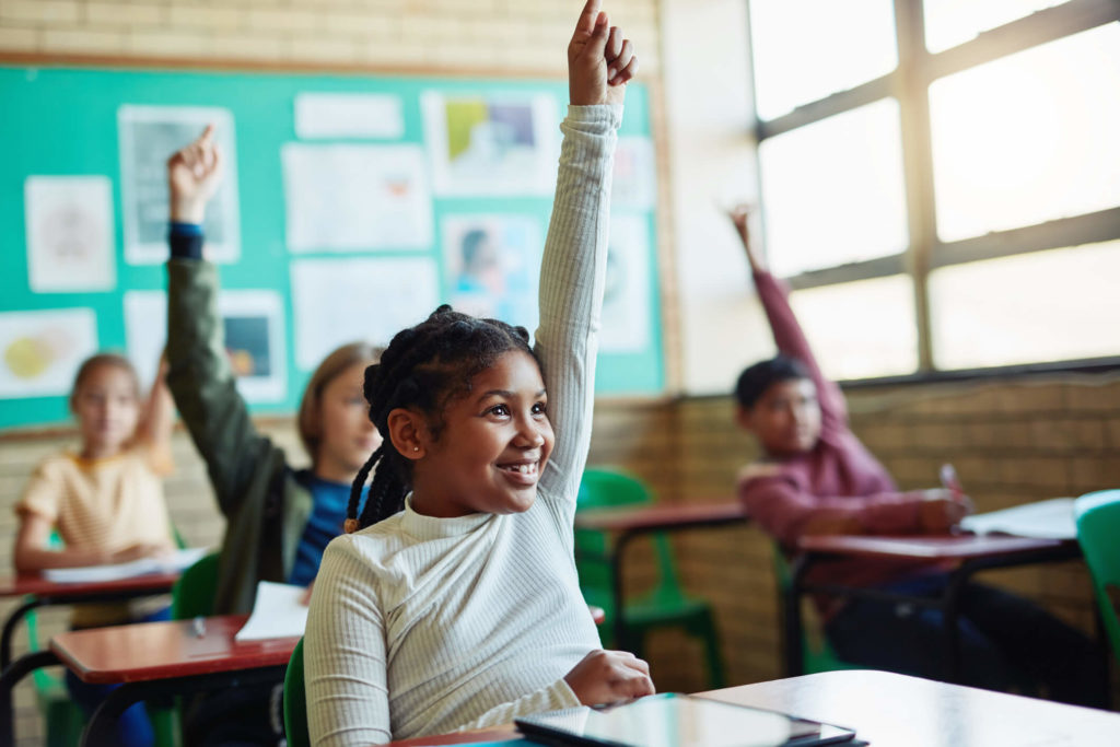 A student raises her hand during a lesson on social justice.