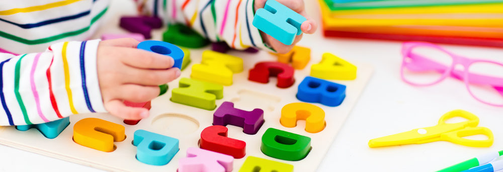 A child plays with a letter learning puzzle.