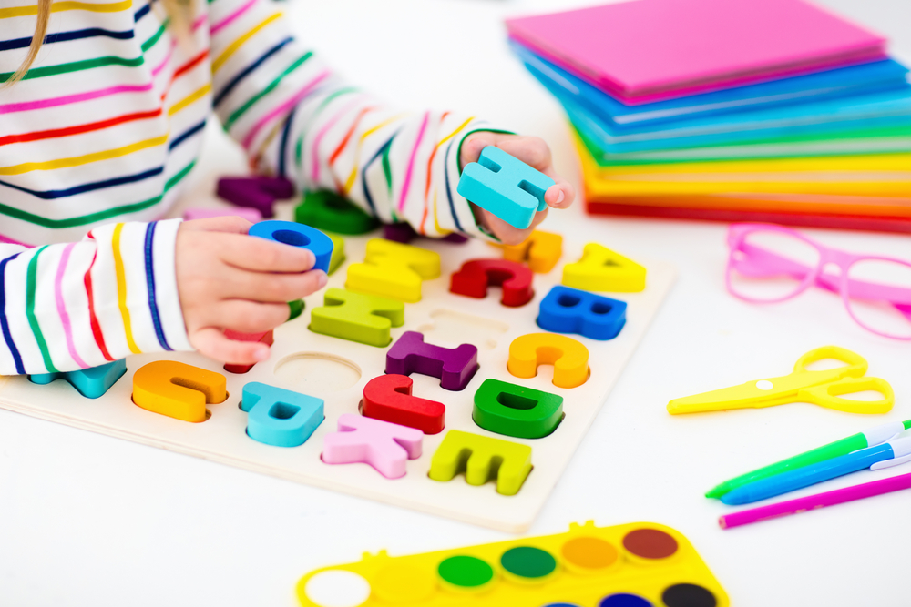 A child plays with a letter learning puzzle.