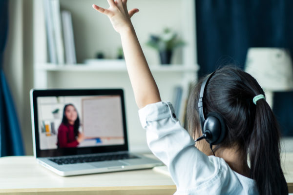 A student raises her hand during virtual learning.