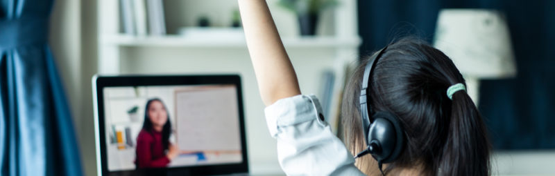 A student raises her hand during virtual learning.