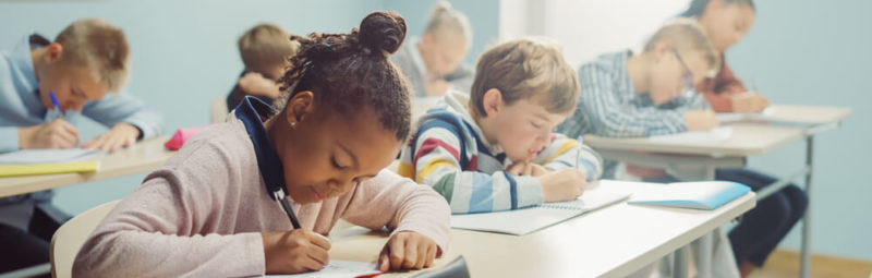 Children sitting at a desk working on homework