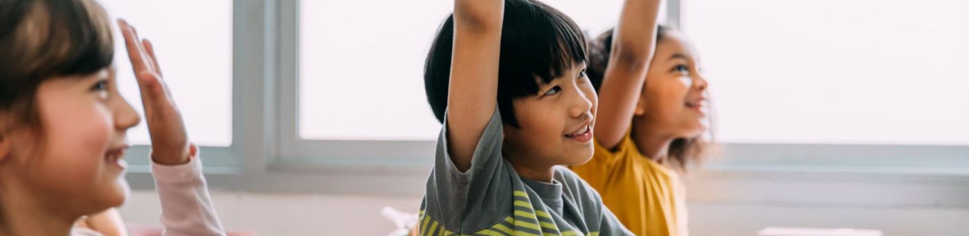 ELL students raise their hands to participate in a speaking activity.