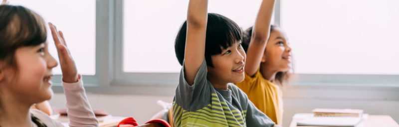 ELL students raise their hands to participate in a speaking activity.