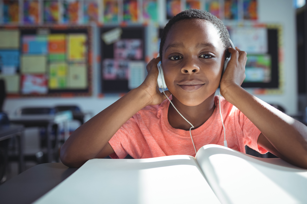 An ELL student uses headphones to complete a listening activity.