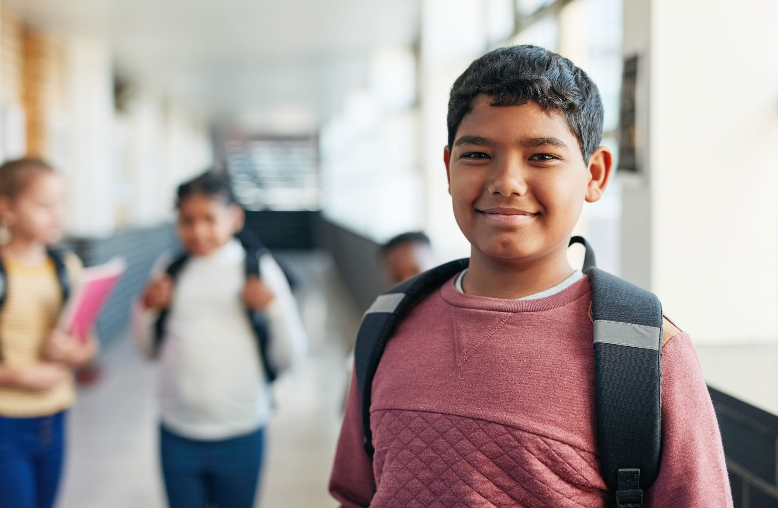 A smiling boy in the hallway of the school.