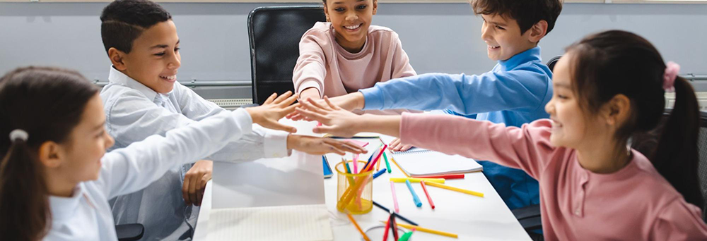 A group of five students work together at a table.