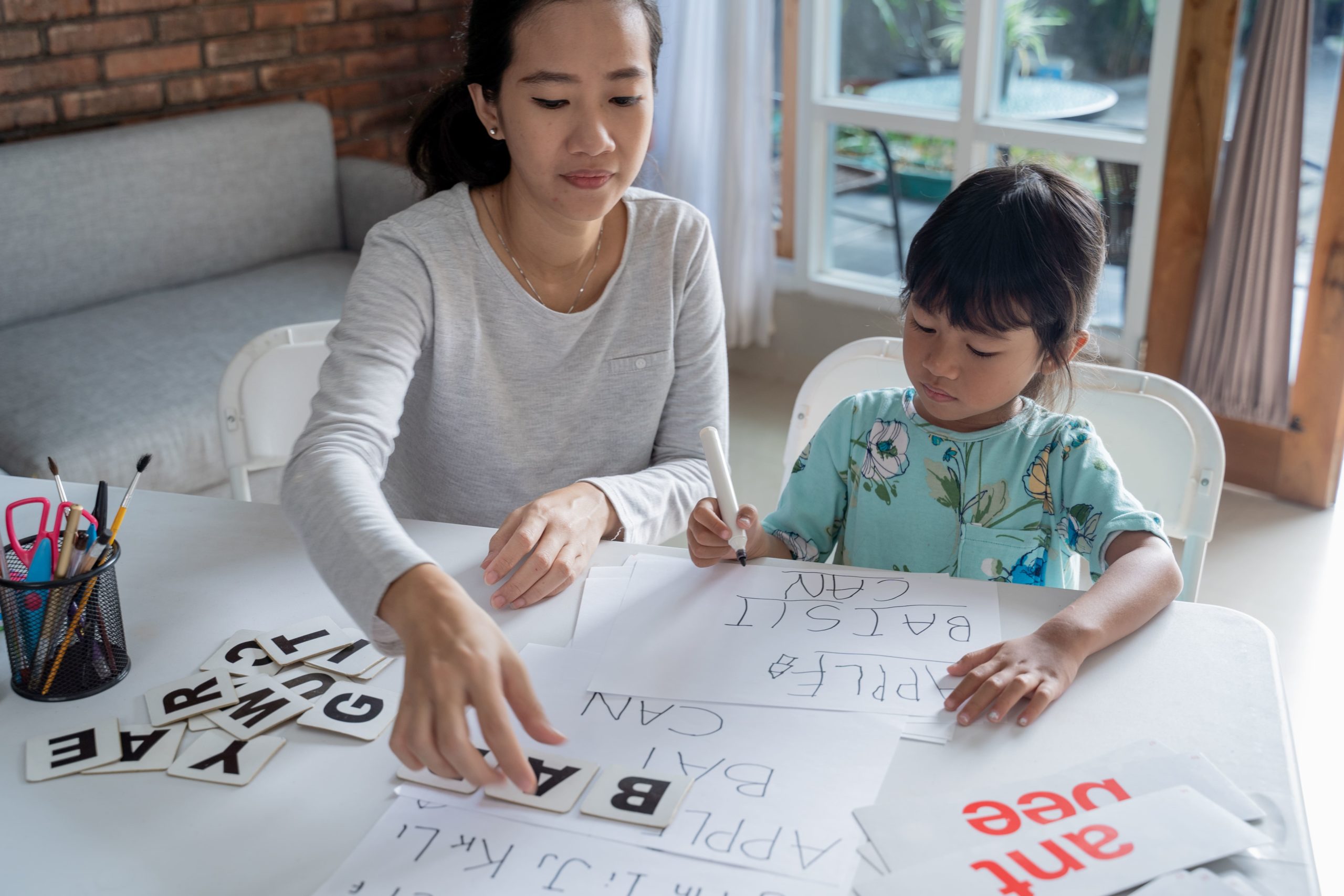 Teacher helping student with letters