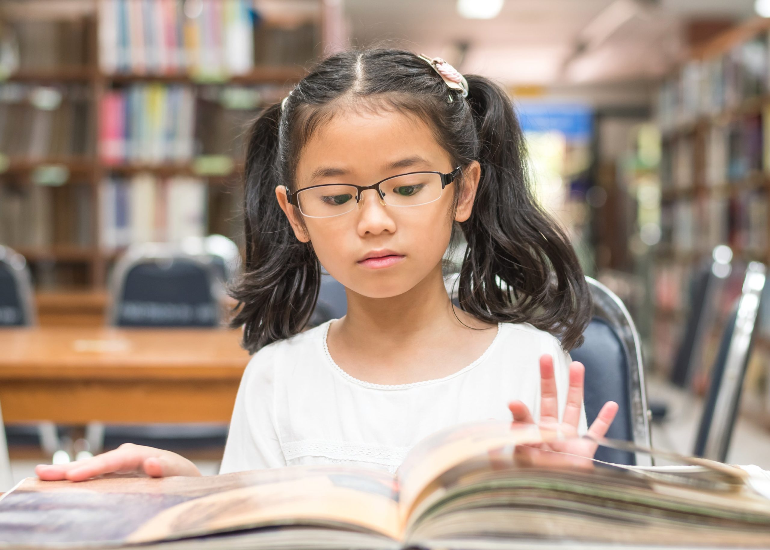 Young girl reading in the library.