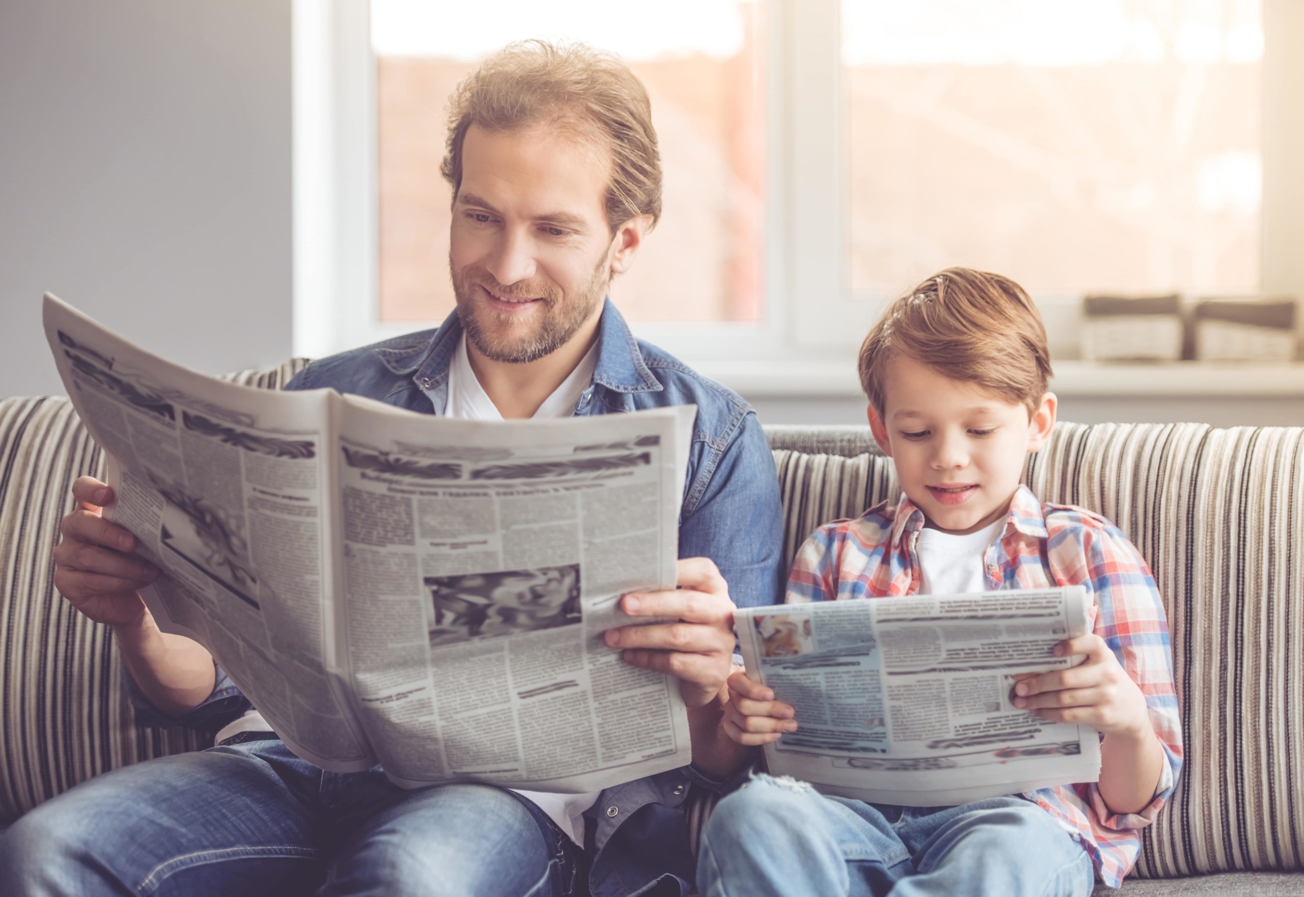 Father and son reading newspapers.