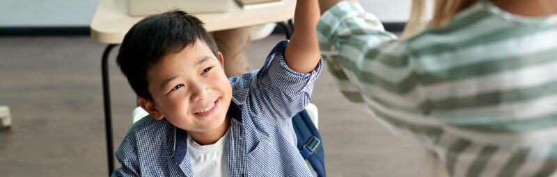 Teacher giving a student a high-five.