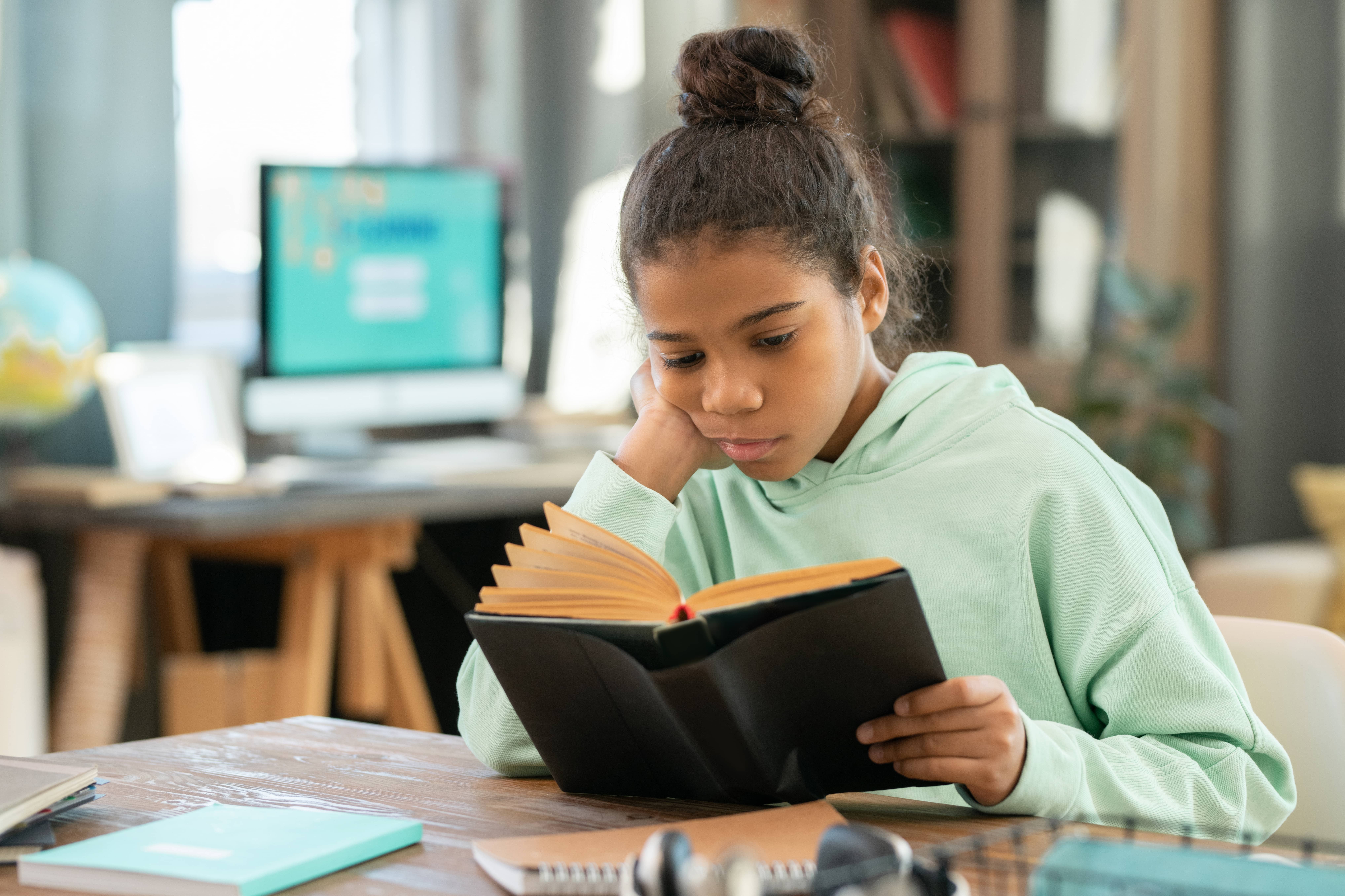 Middle school student reading in her classroom.