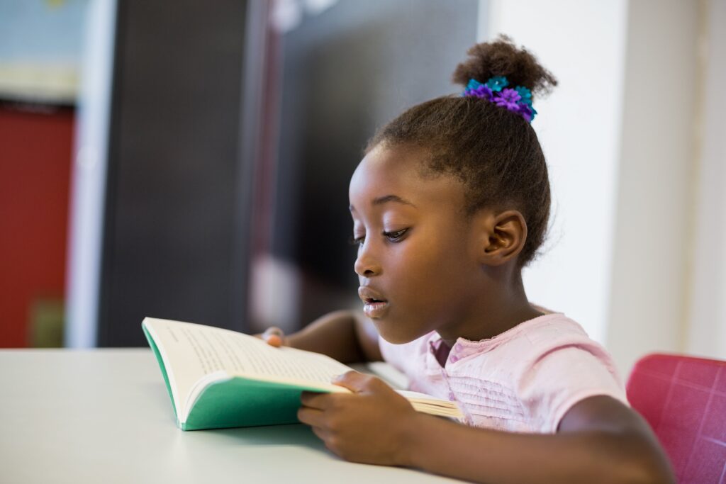 Young elementary student reading at her desk.