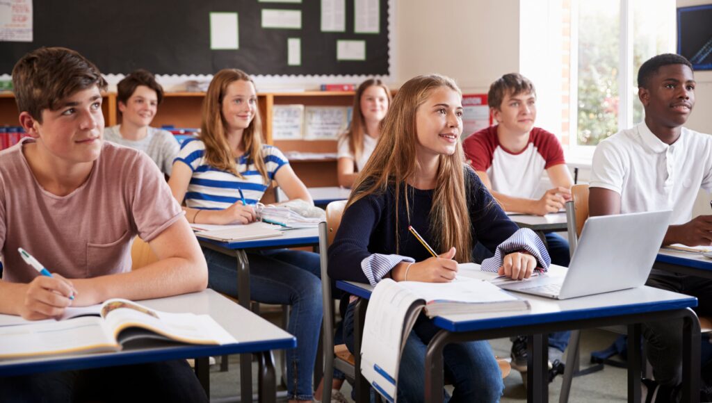 Older students listening intently to a lesson at their desks.