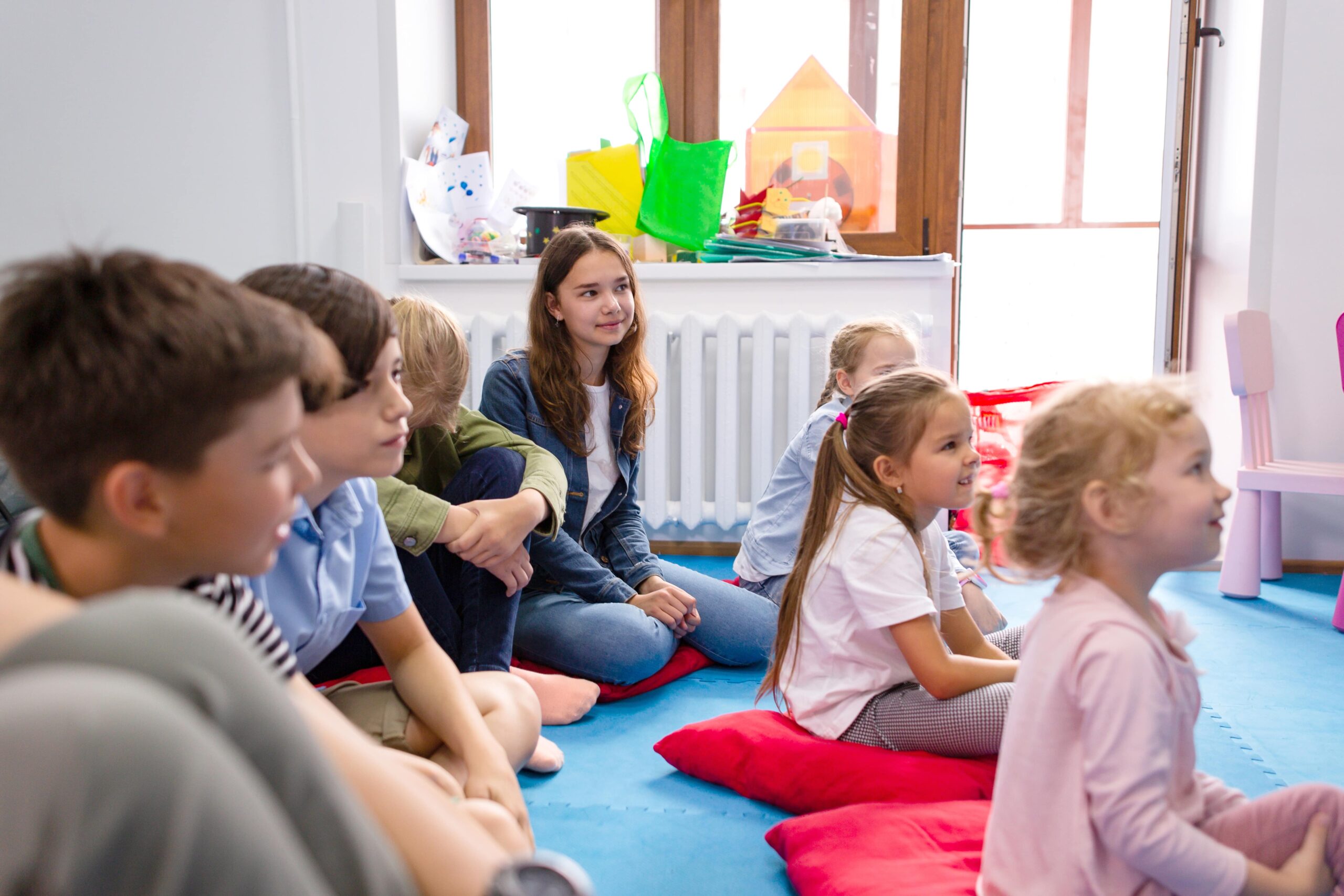 Students sitting on the ground for show and tell.