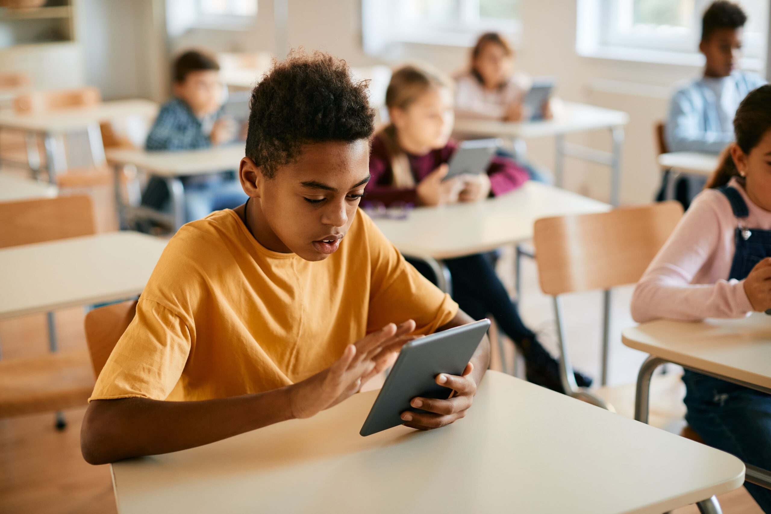Student using tablet for reading game in class.