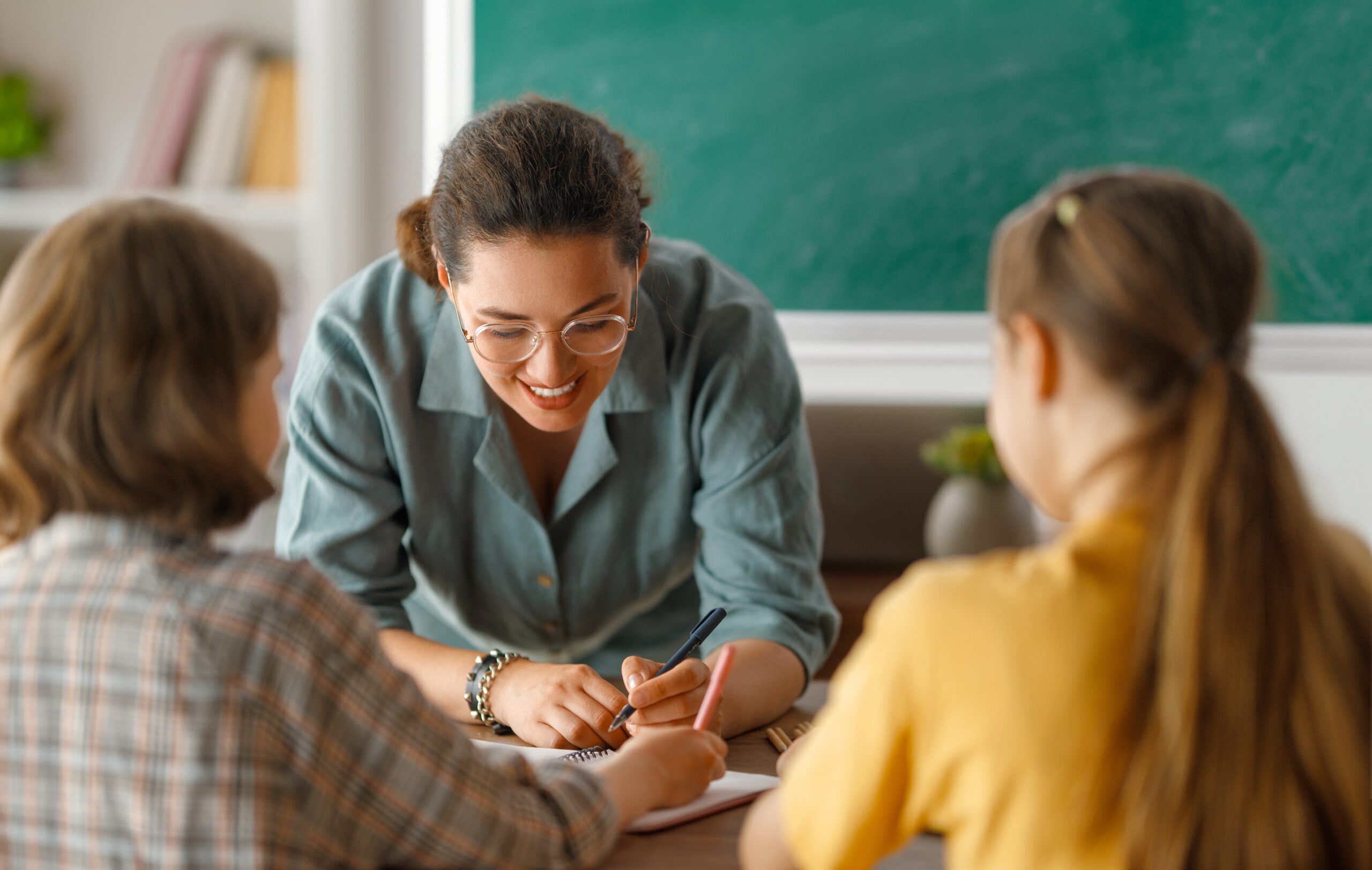 Teacher helping students at their desks.