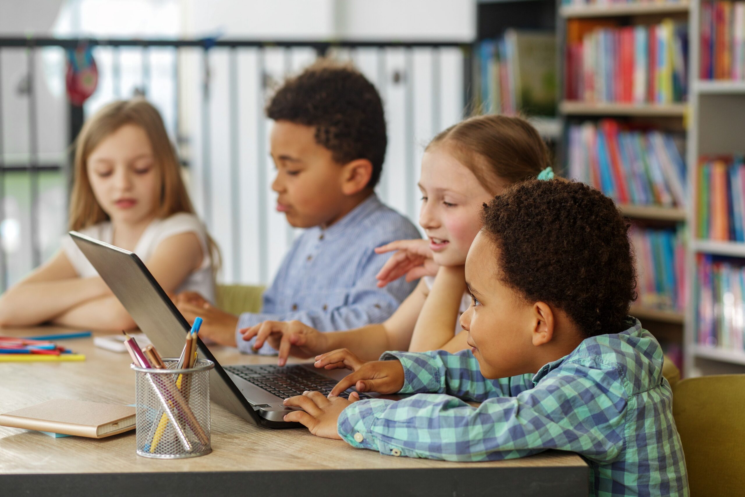 Four young students studying in a library together.